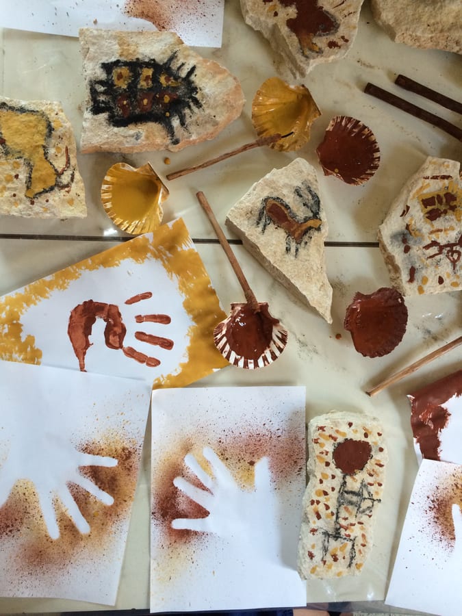 Impronte di mani, disegni su pietra e pigmenti sul tavolo